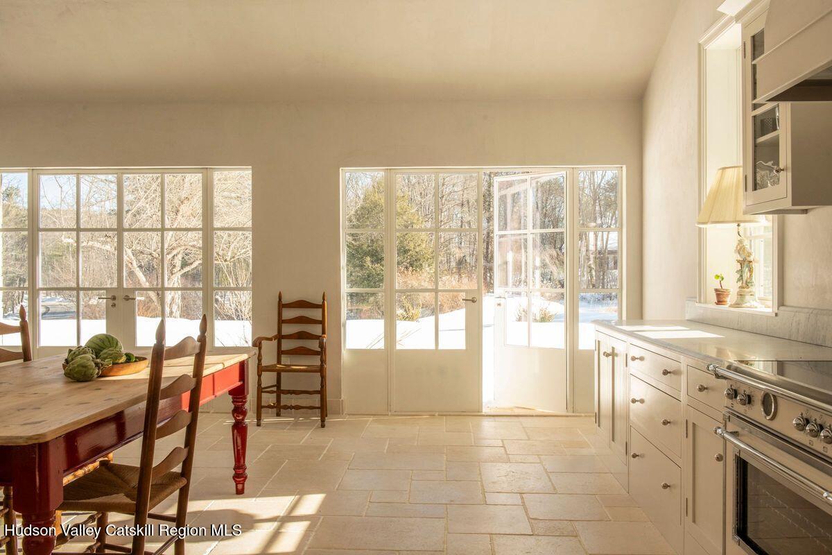401 Buck Road Stone Ridge, NY 12484 - Photo 7 of 32 a open kitchen with granite countertop a stove top oven dining table and chairs