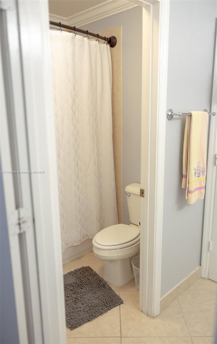 3923 Cascade Terrace Weston, FL 33332 - Photo 56 of 82 a white toilet sitting next to a shower curtain