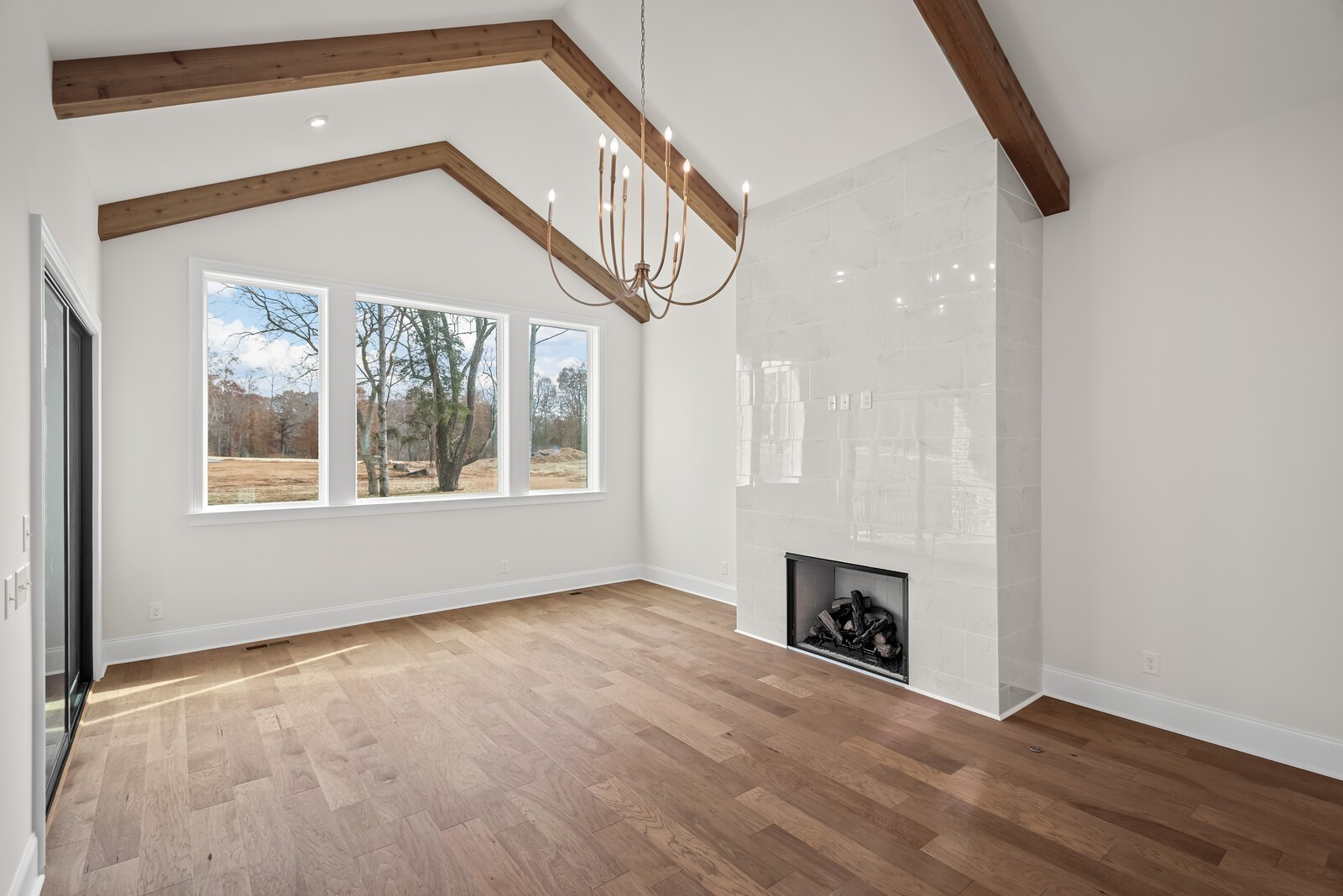 7217 Severide Street Fairview, TN 37062 - Photo 26 of 63 an empty room with wooden floor fireplace and windows