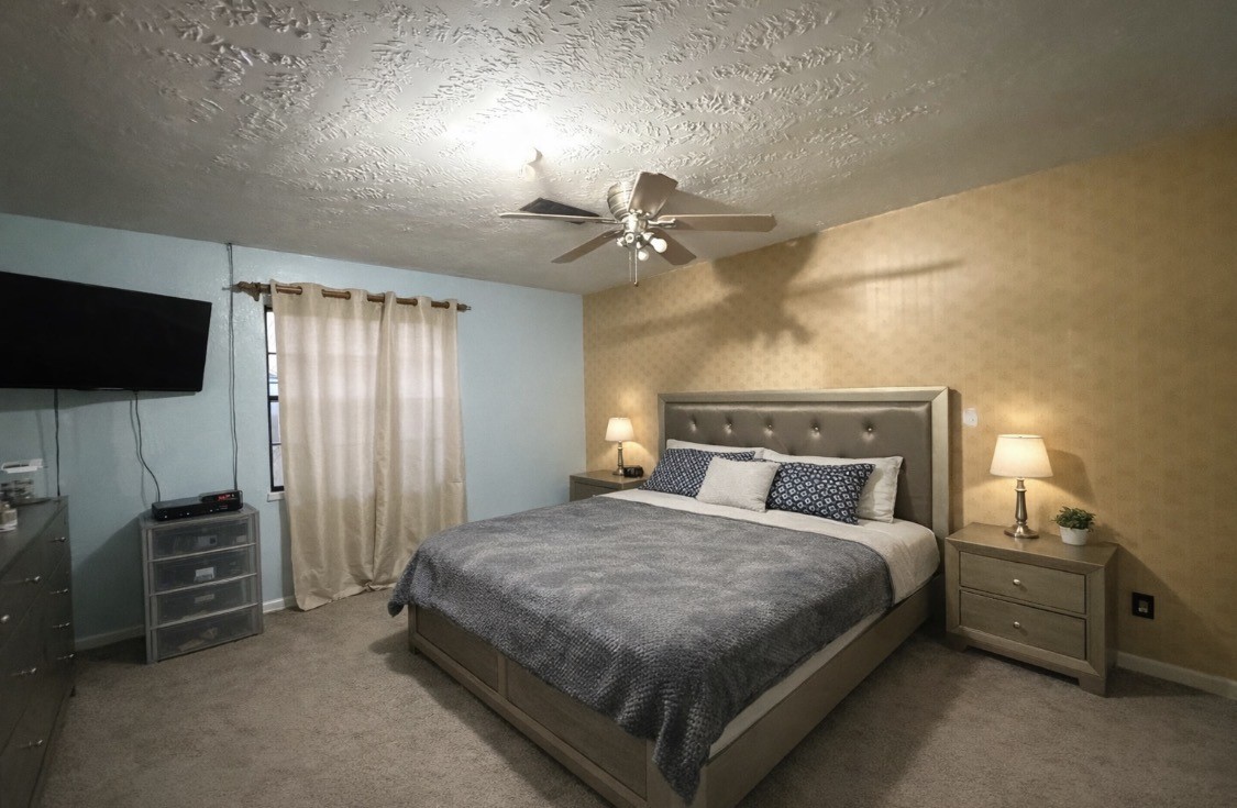 2102 Snowdrop Lane Houston, TX 77067 - Photo 5 of 9 a bedroom with a bed and a flat tv screen on dresser