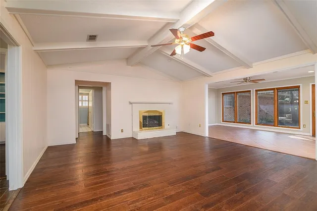 a large kitchen with stainless steel appliances kitchen island granite countertop white cabinets a sink dishwasher and a stove with wooden floor