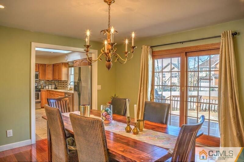 36 Edgewood Road Edison, NJ 08820 - Photo 6 of 23 a dining room with wooden floor a chandelier a glass table and chairs