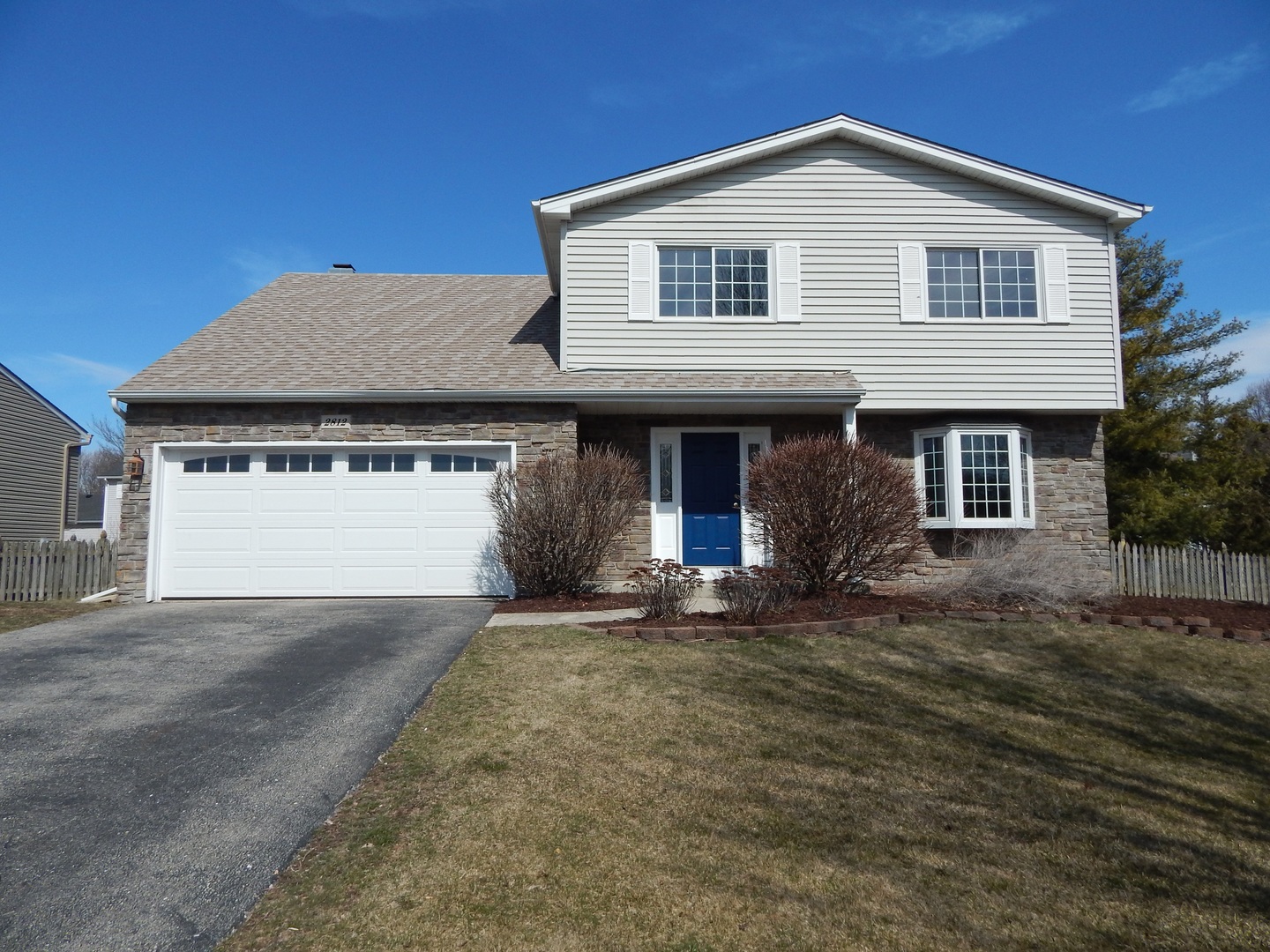 a front view of a house with a garden and yard