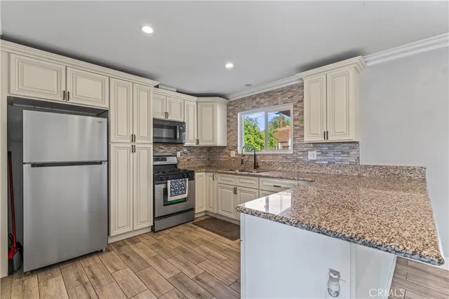 a kitchen with granite countertop a stove sink and microwave