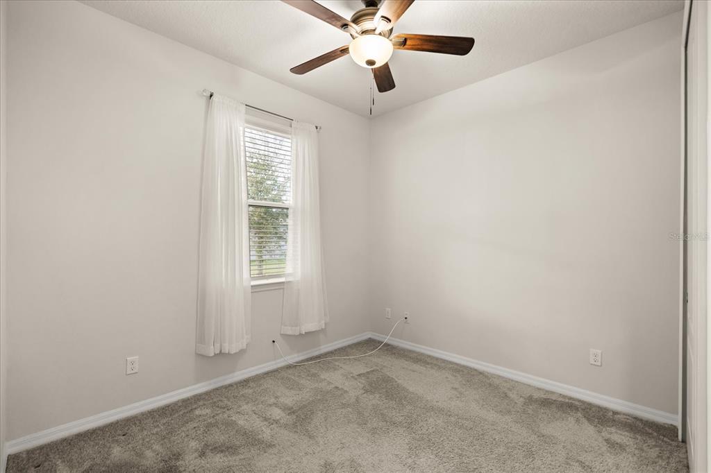 5192 Chickadee Street St. Cloud, FL 34771 - Photo 13 of 35 an empty room with a window and a fan