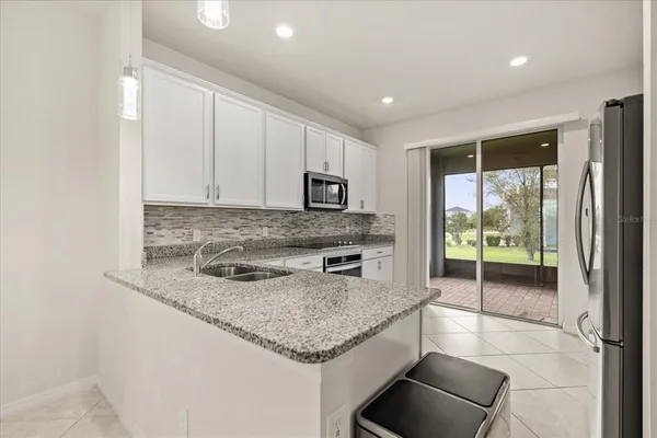 a kitchen with granite countertop a stove a sink and a microwave