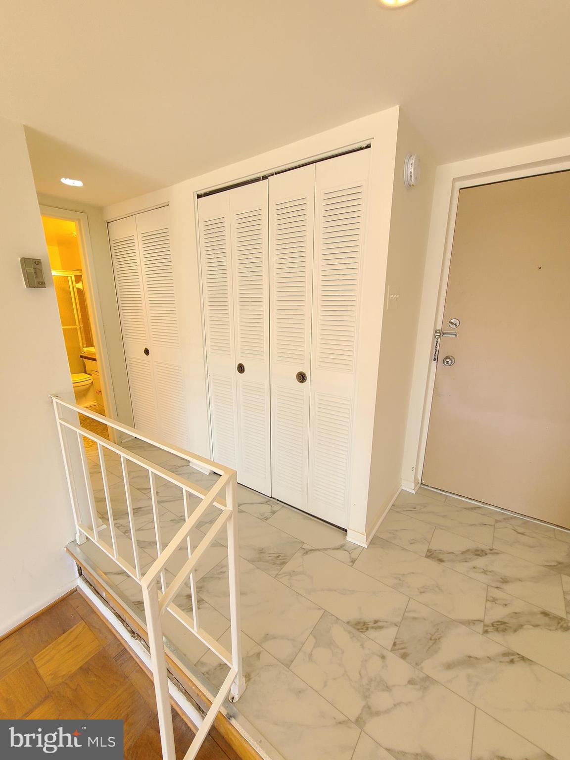 9900 Georgia Avenue, Unit 310 Silver Spring, MD 20902 - Photo 6 of 16 a view of a hallway with wooden floor and staircase