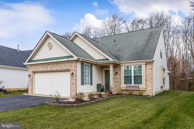 a front view of a house with a garden and yard