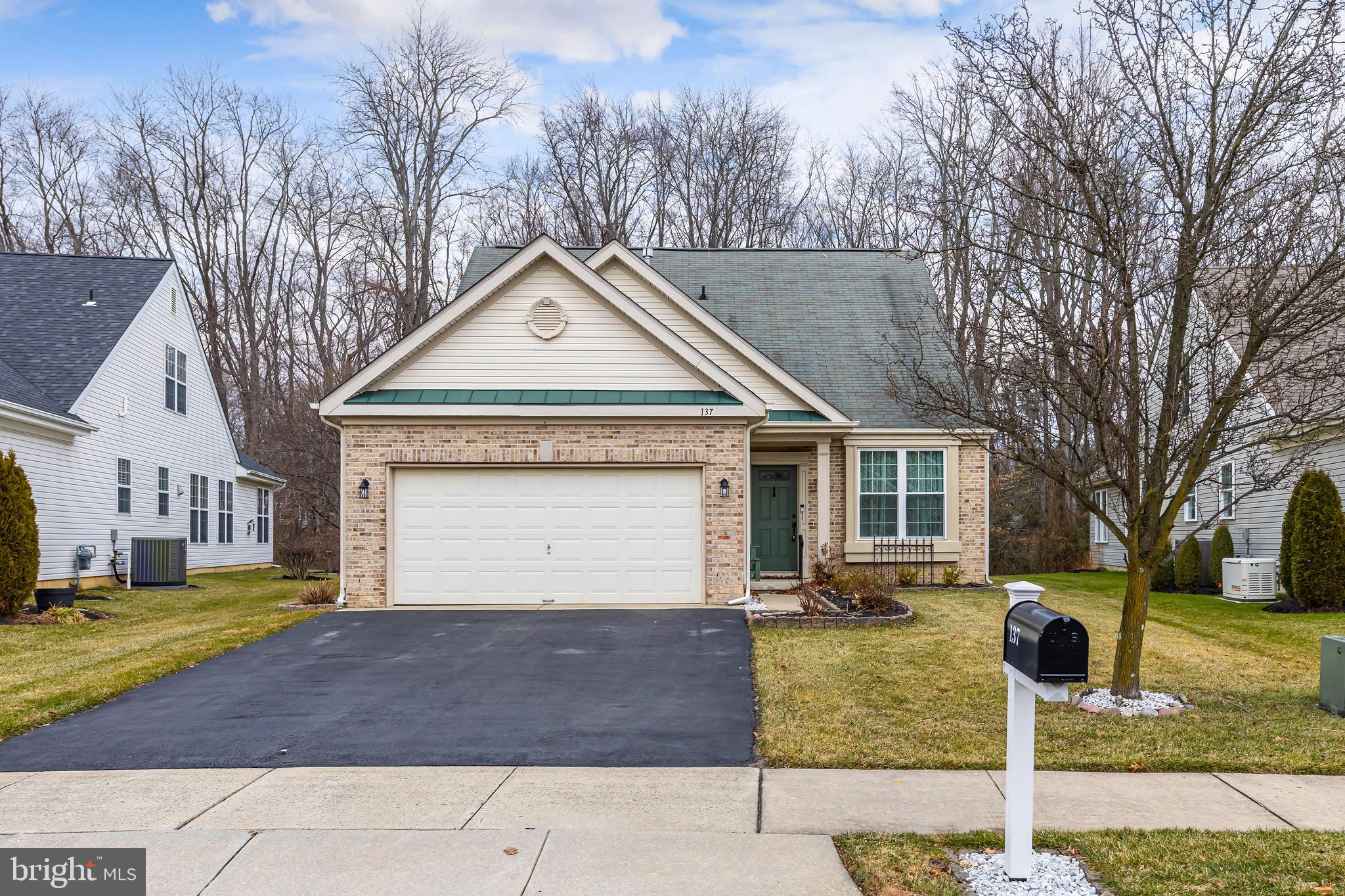 137 Merion Way Hainesport, NJ 08036 - Photo 2 of 26 a front view of a house with a yard and garage