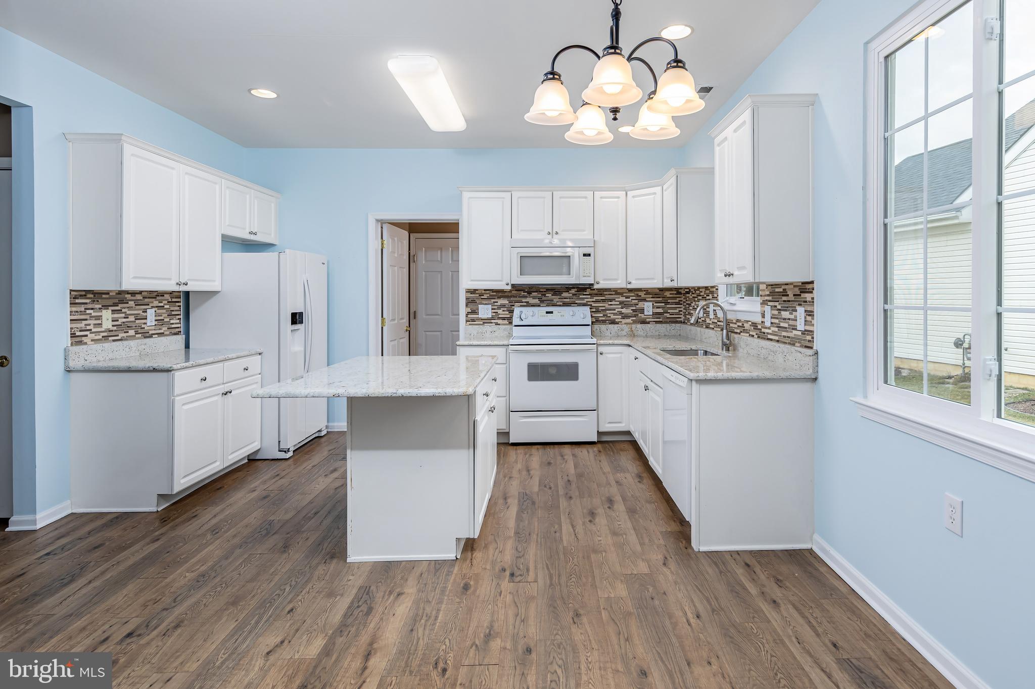137 Merion Way Hainesport, NJ 08036 - Photo 5 of 26 a large kitchen with a large window a kitchen island stainless steel appliances and wooden floor