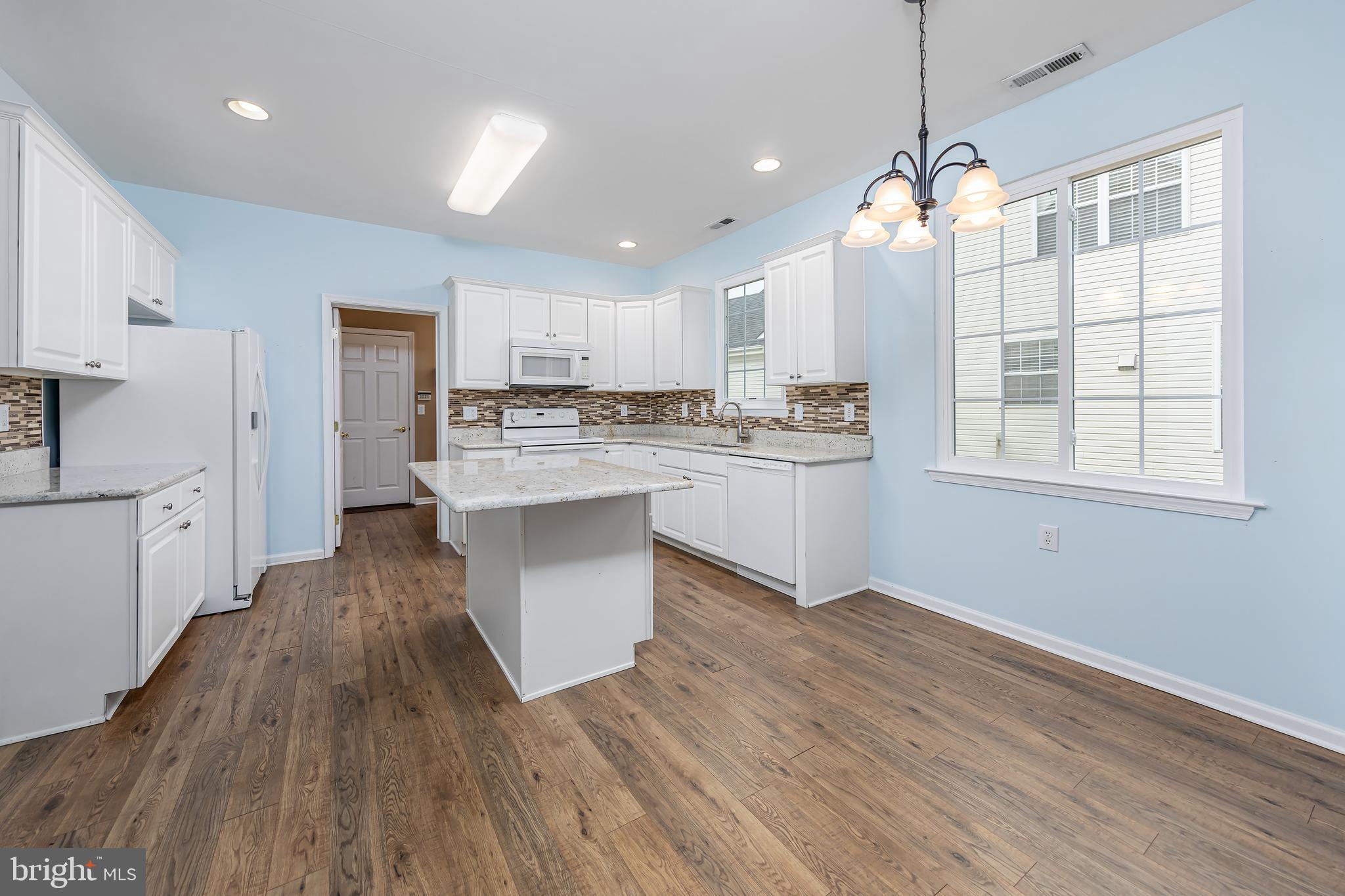 137 Merion Way Hainesport, NJ 08036 - Photo 6 of 26 a large kitchen with kitchen island a stove a sink dishwasher a refrigerator and white cabinets with wooden floor