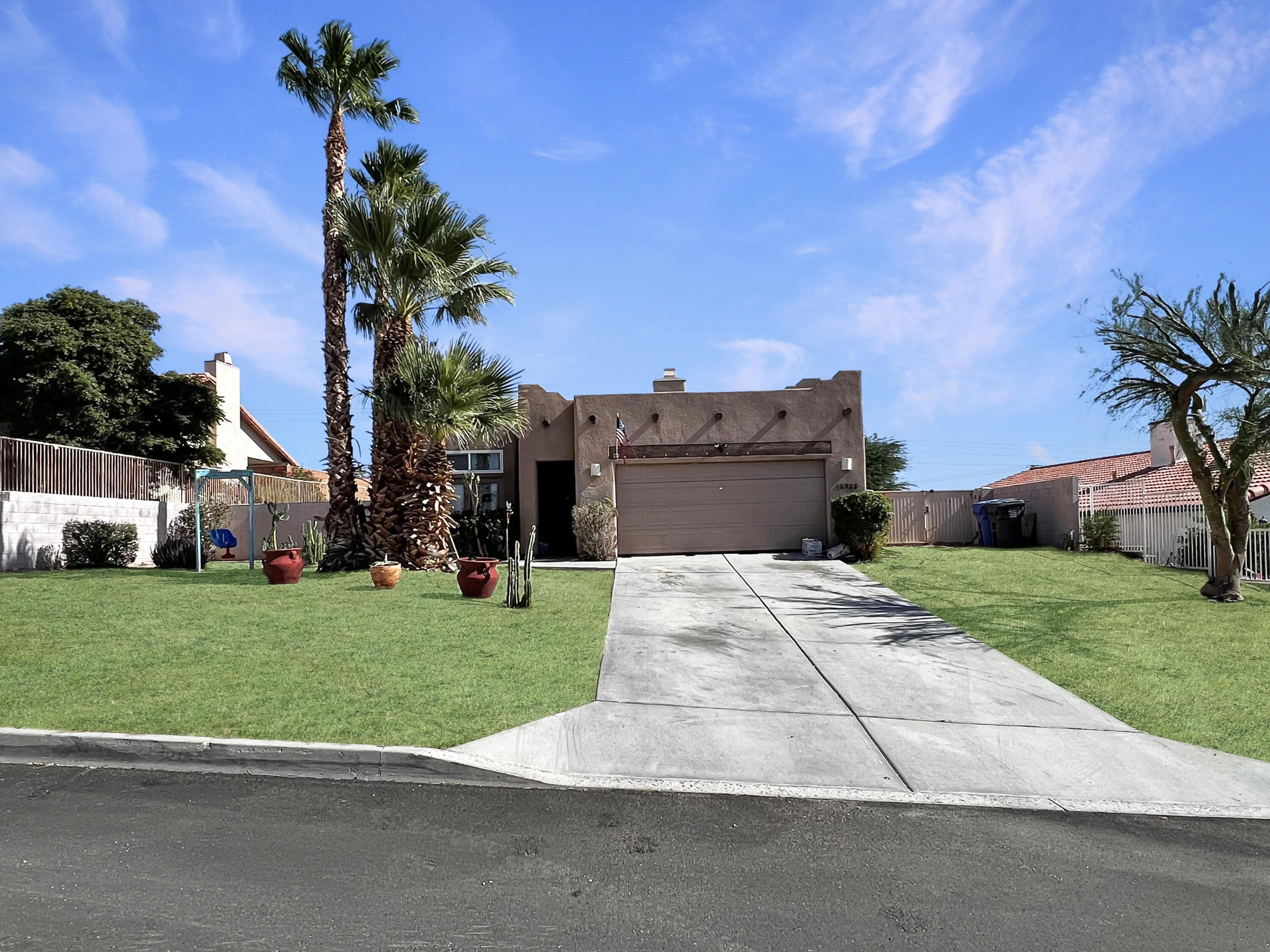 12928 Agua Cayendo Road Desert Hot Springs, CA 92240 - Photo 1 of 21 a front view of a house with a yard and garage