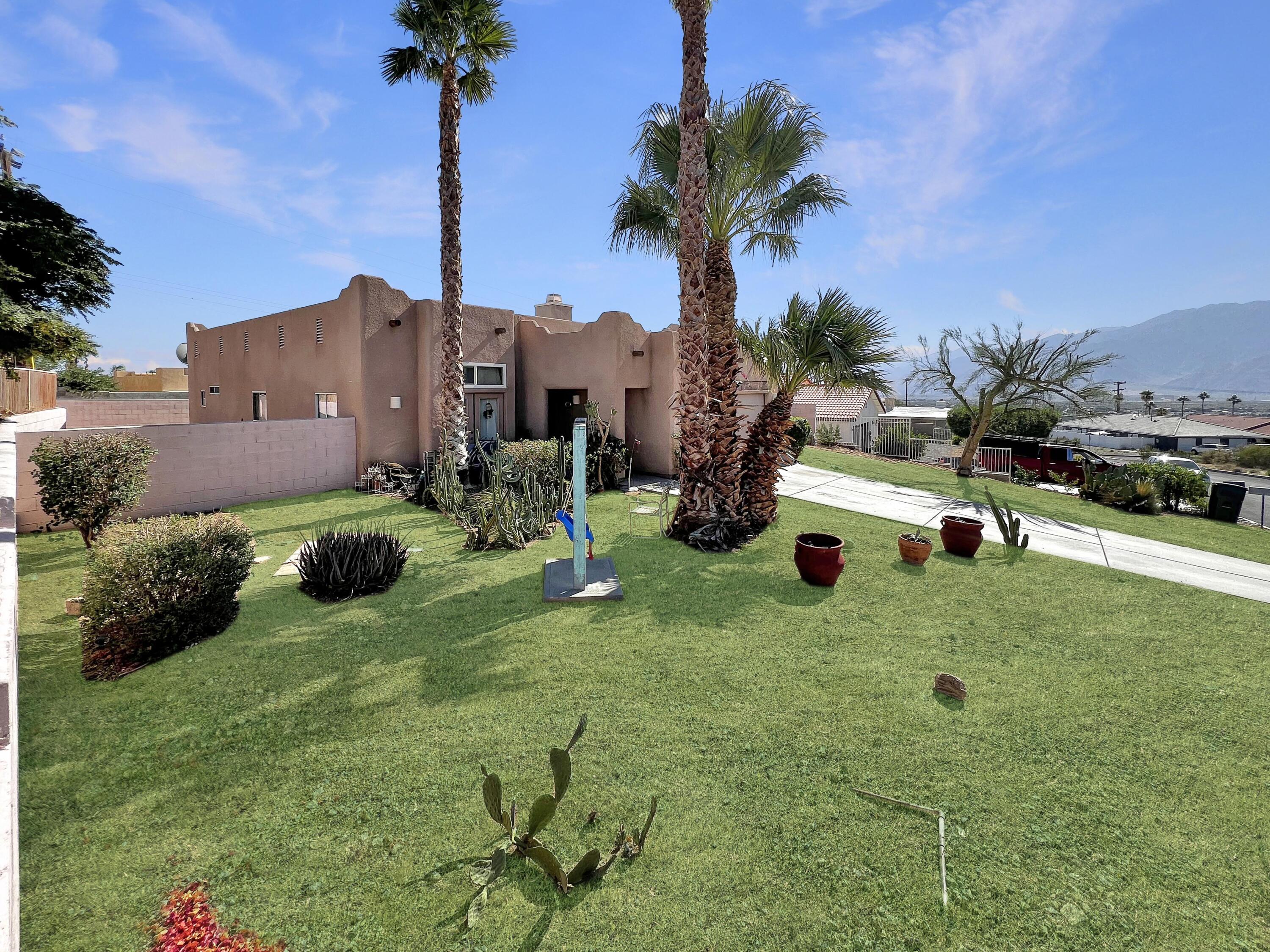 12928 Agua Cayendo Road Desert Hot Springs, CA 92240 - Photo 18 of 21 a view of a house with a backyard and a tree