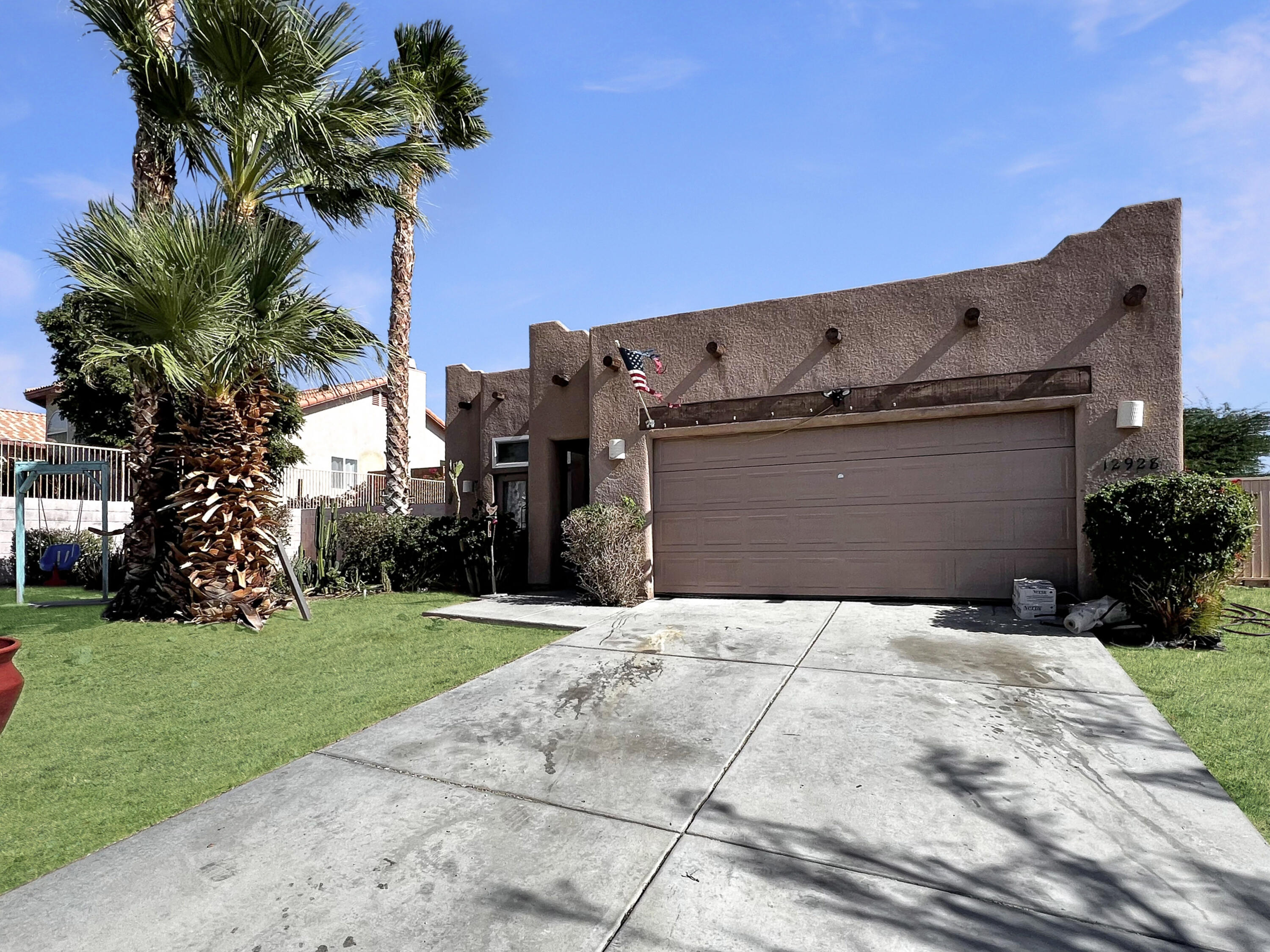 12928 Agua Cayendo Road Desert Hot Springs, CA 92240 - Photo 20 of 21 a front view of a house with a yard and garage