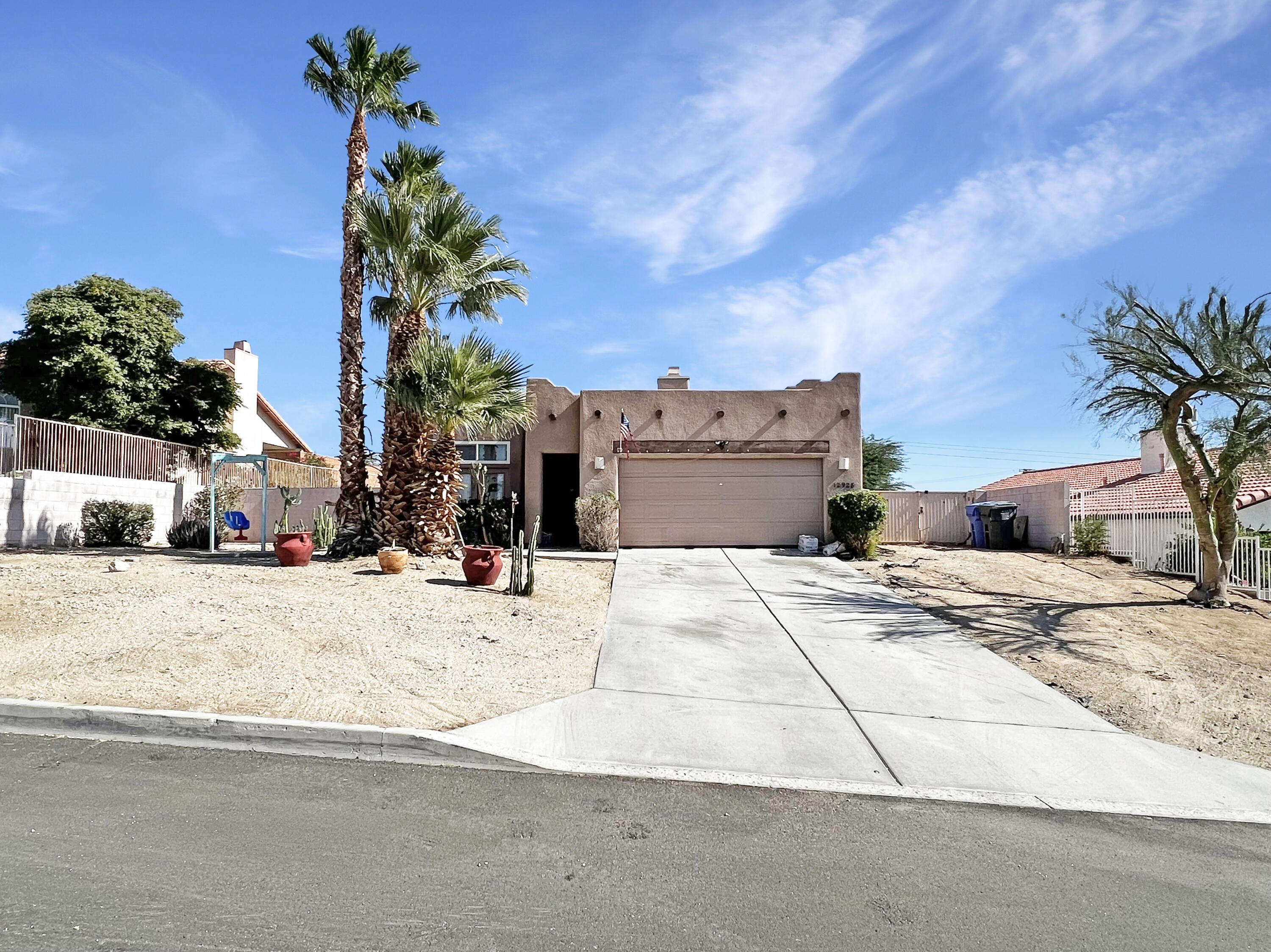 12928 Agua Cayendo Road Desert Hot Springs, CA 92240 - Photo 2 of 21 a view of a house with a yard and garage