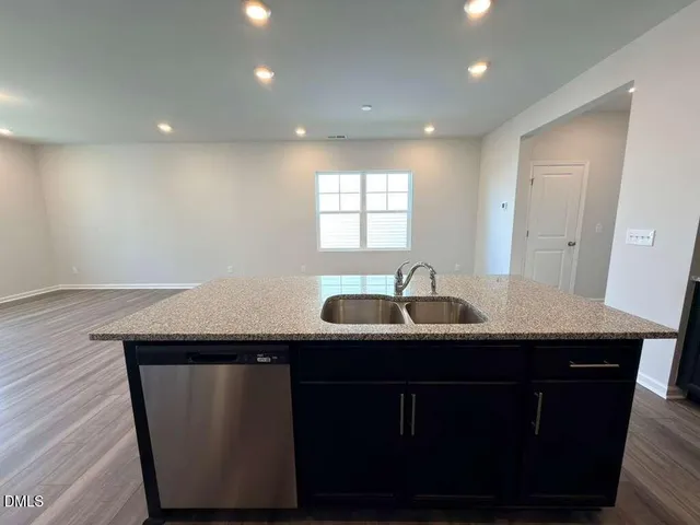 a kitchen with a sink a window and wooden floor