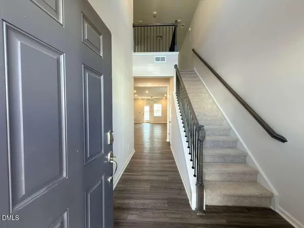 a view of a hallway with wooden floor and staircase