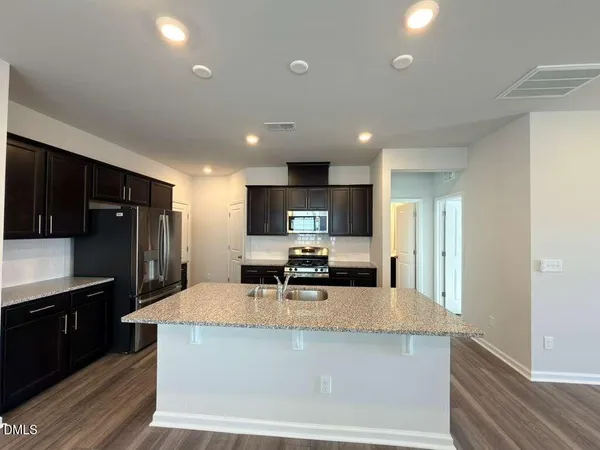 a kitchen with kitchen island a sink and a stove