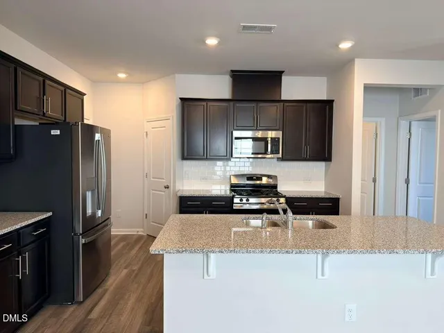 a kitchen with a refrigerator a microwave a sink and stove
