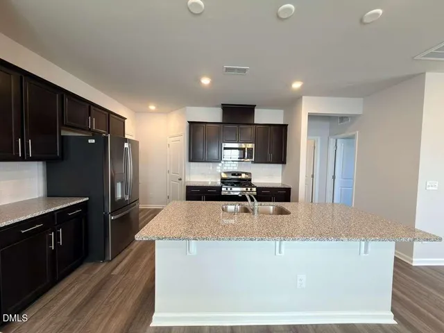a large kitchen with stainless steel appliances and a refrigerator