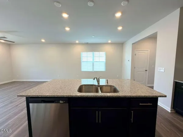 a kitchen with a sink cabinets and wooden floor