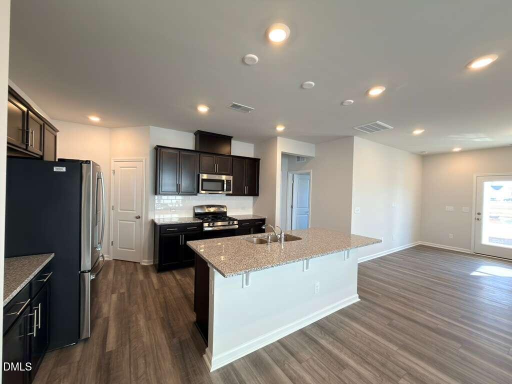 2007 English Saddle Lane Durham, NC 27703 - Photo 8 of 45 a large kitchen with stainless steel appliances a refrigerator a stove top oven a sink dishwasher and wooden floor