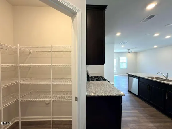 a kitchen with kitchen island a sink wooden floor and a refrigerator
