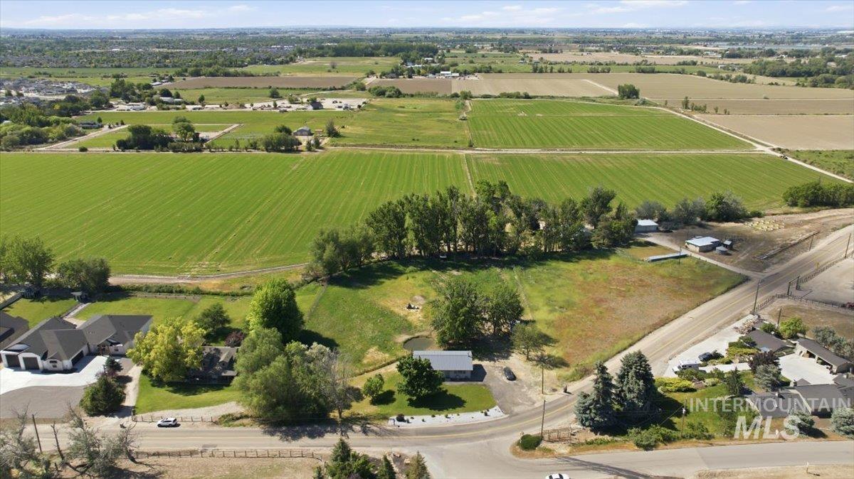 6323 Foothill Road Star, ID 83669 - Photo 37 of 50 Expansive aerial showcasing a large parcel of land featuring a pond, mature trees, and multiple outbuildings, surrounded by agricultural fields