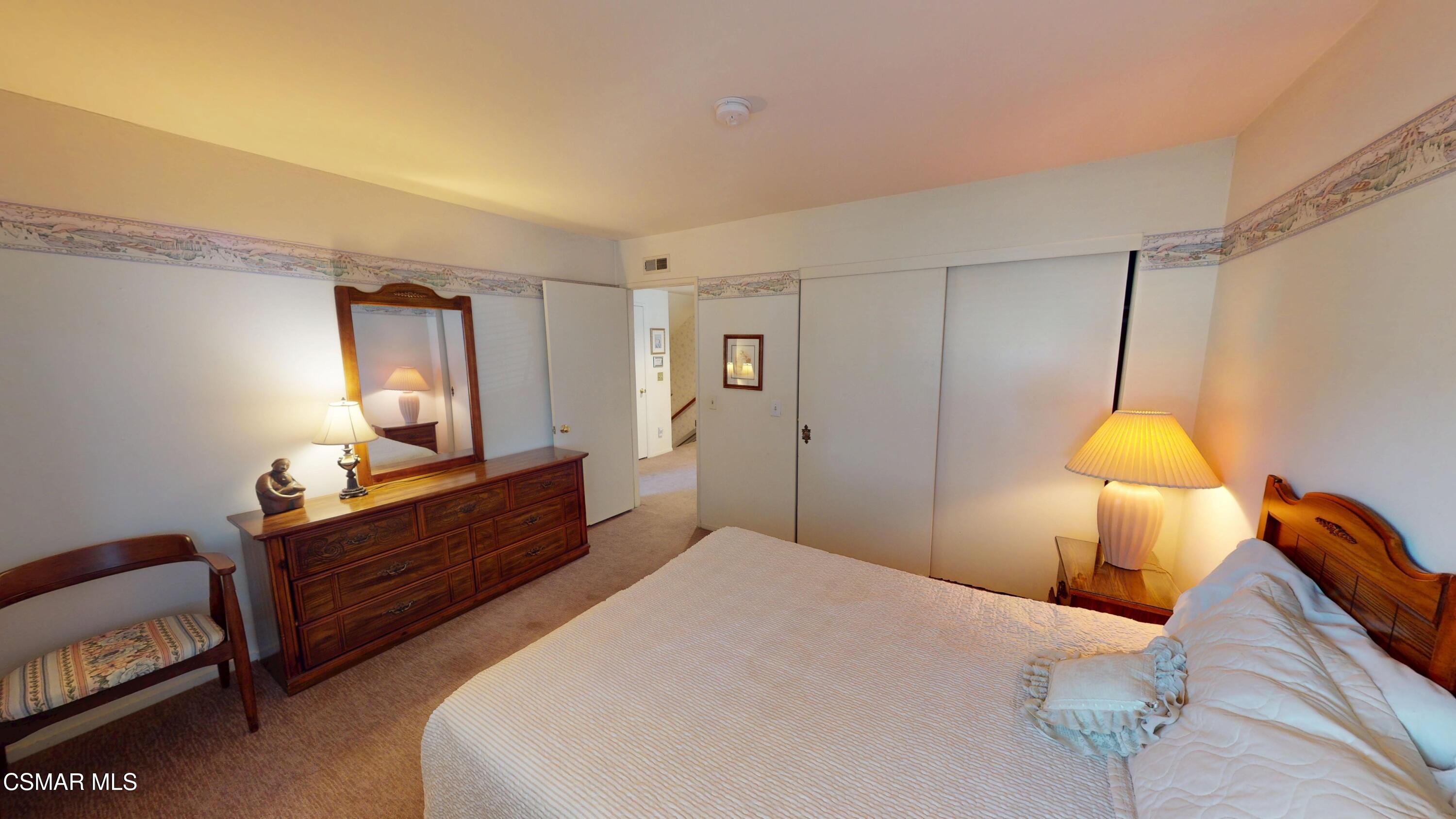 10900 Des Moines Avenue Porter Ranch, CA 91326 - Photo 22 of 38 a bedroom with a bed and a lamp on dresser