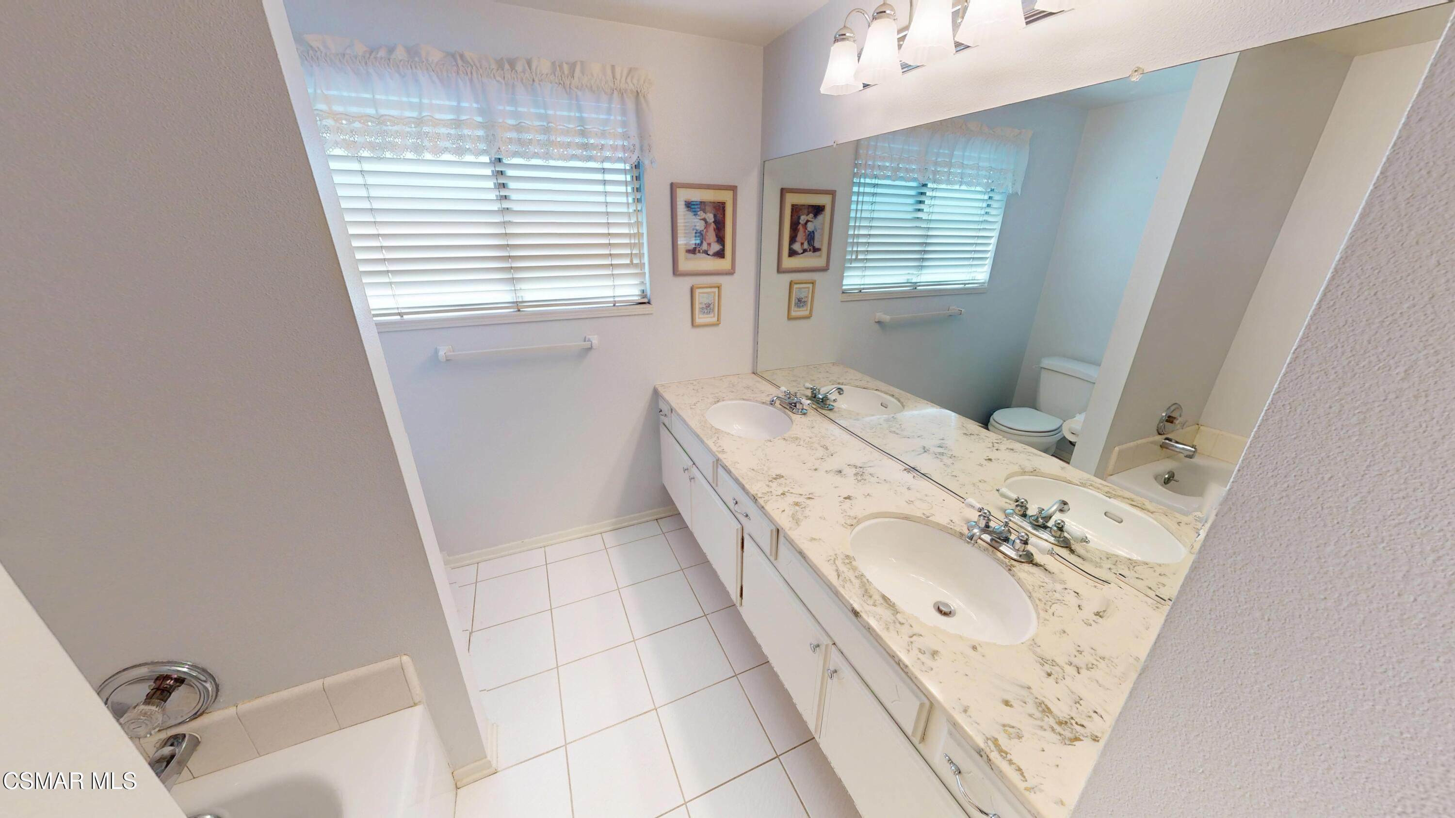 10900 Des Moines Avenue Porter Ranch, CA 91326 - Photo 25 of 38 a spacious bathroom with a bathtub sink and mirror