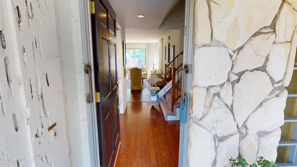 a view of a hallway with wooden cabinets and stairs
