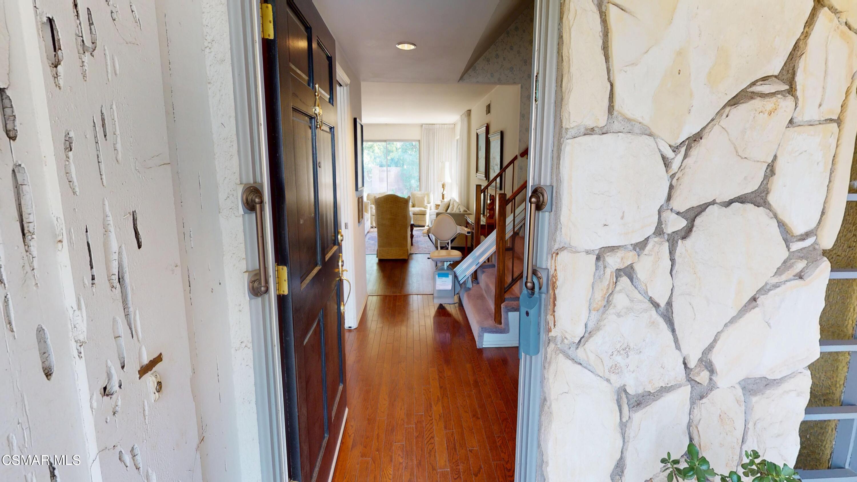 10900 Des Moines Avenue Porter Ranch, CA 91326 - Photo 4 of 38 a view of a hallway with wooden cabinets and stairs