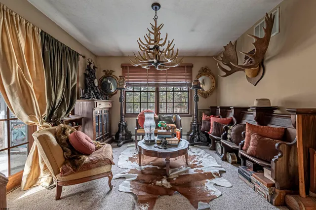 a living room with patio furniture and a chandelier