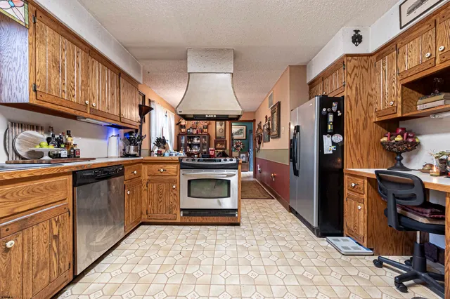 a kitchen with stainless steel appliances granite countertop a refrigerator and a stove