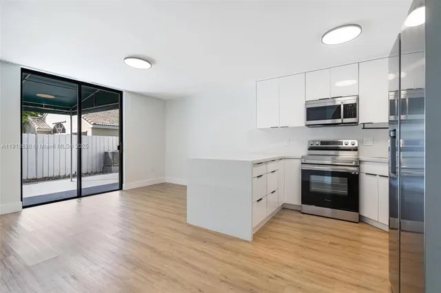 a kitchen with granite countertop a refrigerator and a stove top oven