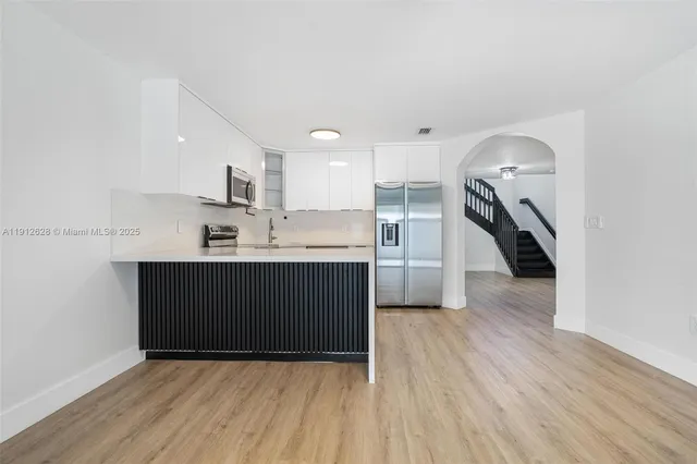 a kitchen with a sink a refrigerator and cabinets