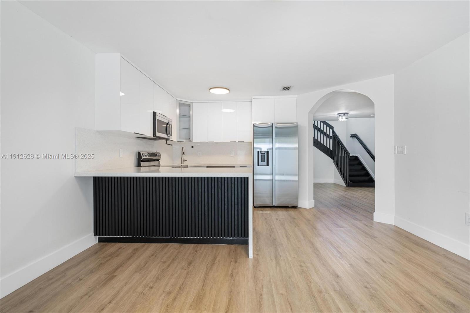 8658 Southwest 159th Court Miami, FL 33193 - Photo 14 of 30 a kitchen with a sink a refrigerator and cabinets
