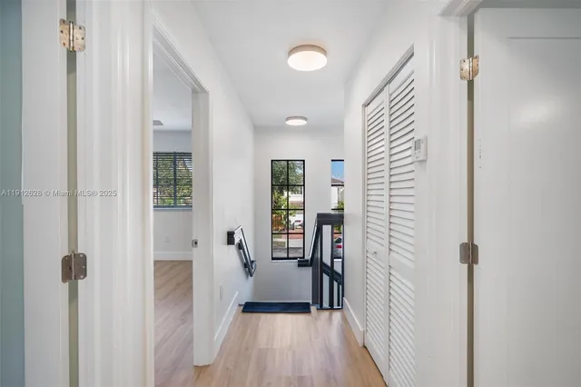 a view of a hallway with wooden floor and staircase