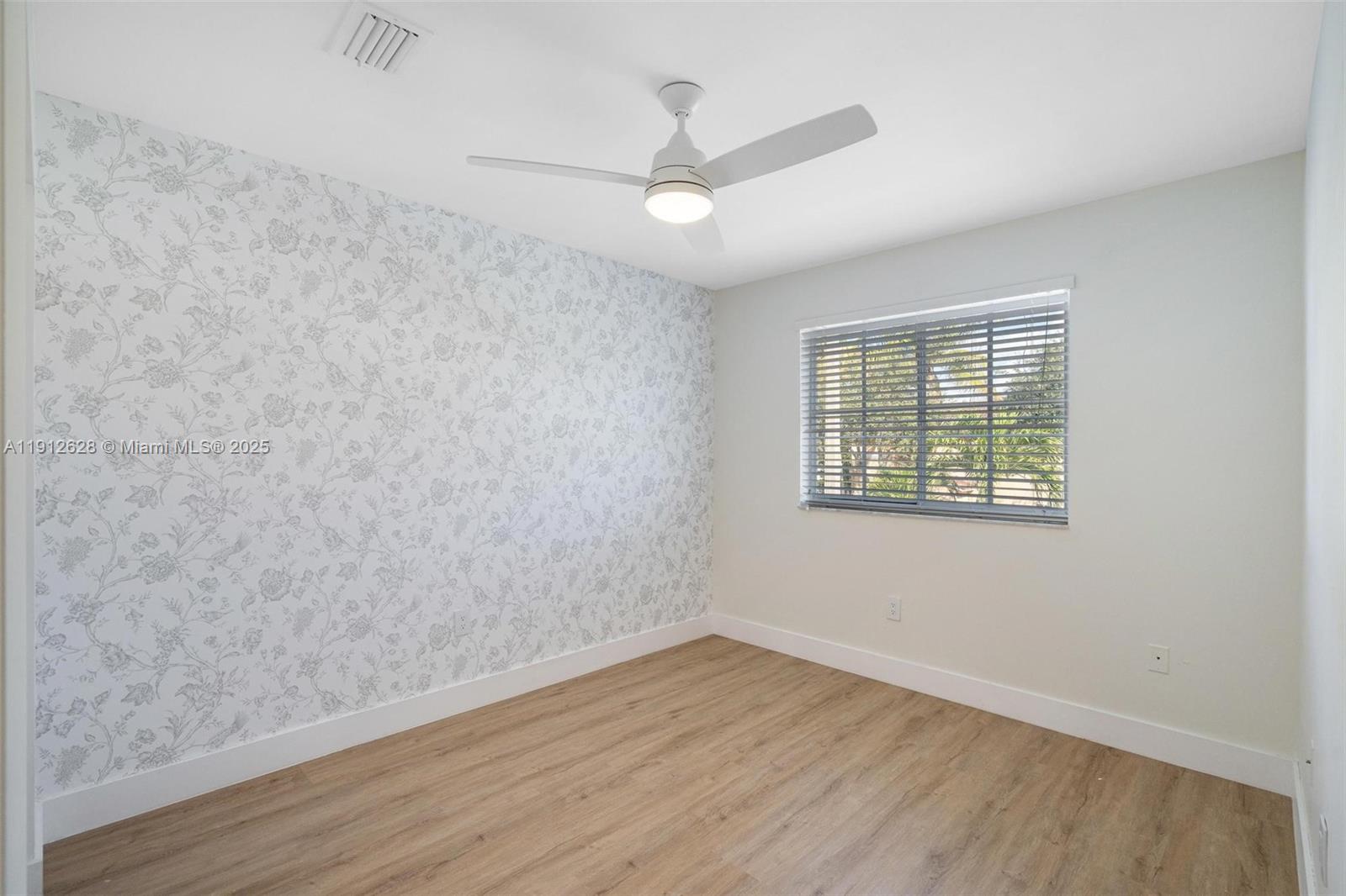 8658 Southwest 159th Court Miami, FL 33193 - Photo 20 of 30 an empty room with wooden floor and windows