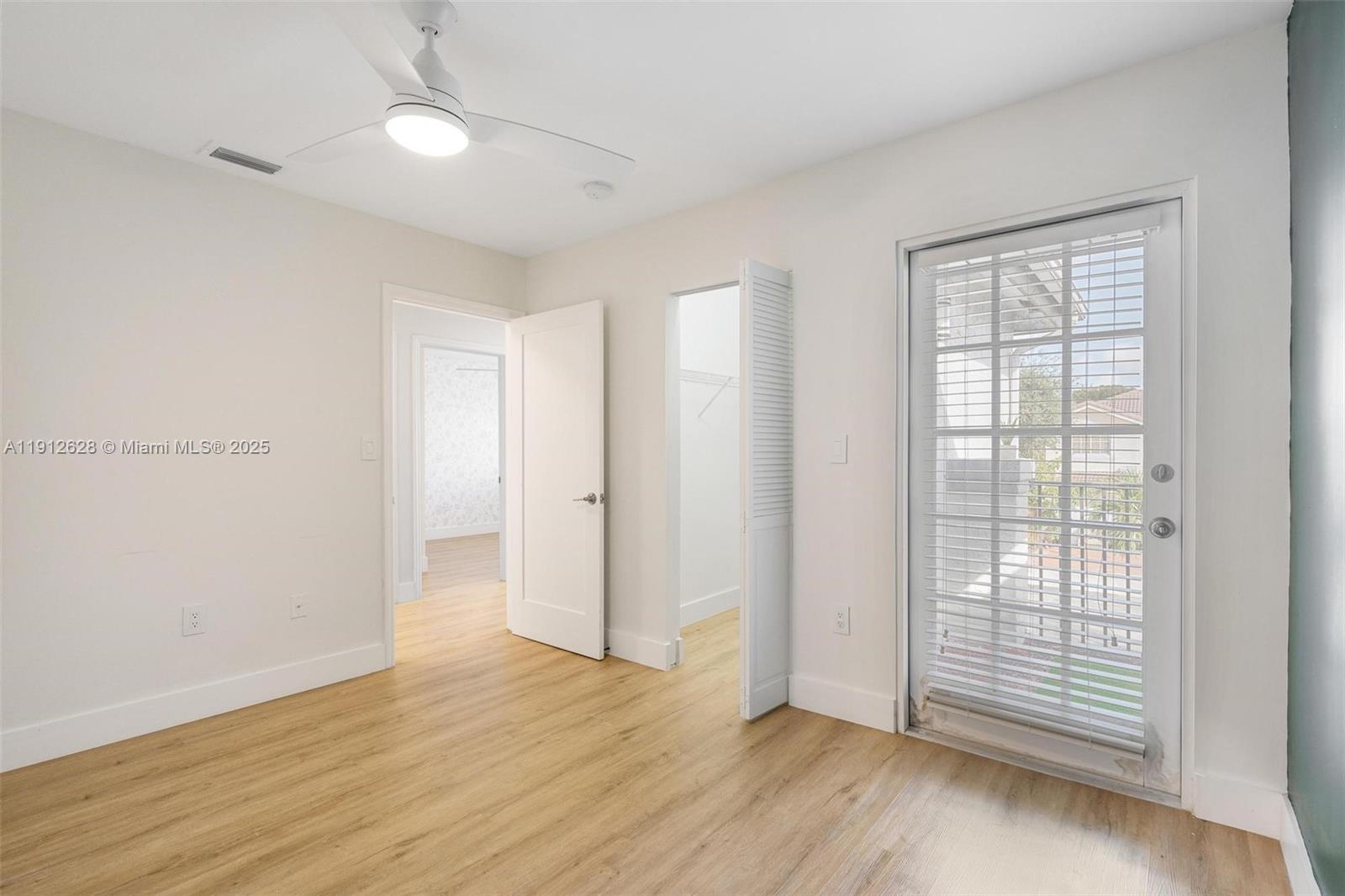 8658 Southwest 159th Court Miami, FL 33193 - Photo 22 of 30 an empty room with wooden floor and windows