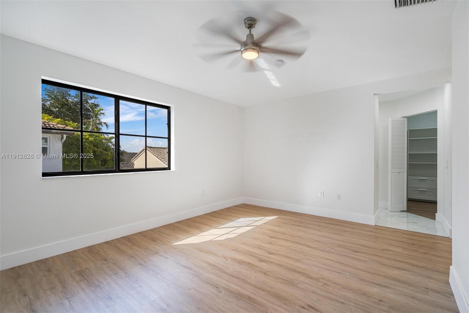 8658 Southwest 159th Court Miami, FL 33193 - Photo 25 of 30 a view of an empty room with wooden floor and a window
