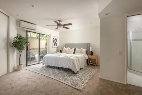 a spacious bedroom with a large bed and a chandelier