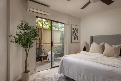 a bedroom with a balcony a bed and a window