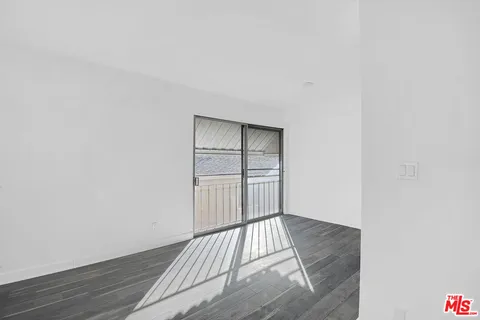 a view of a room with wooden floor and white walls