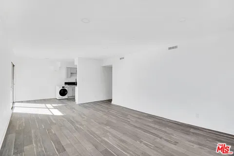 a view of an empty room and wooden floor