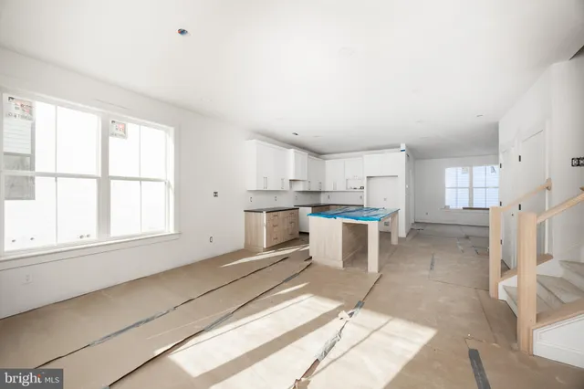 a open kitchen with white cabinets and white appliances