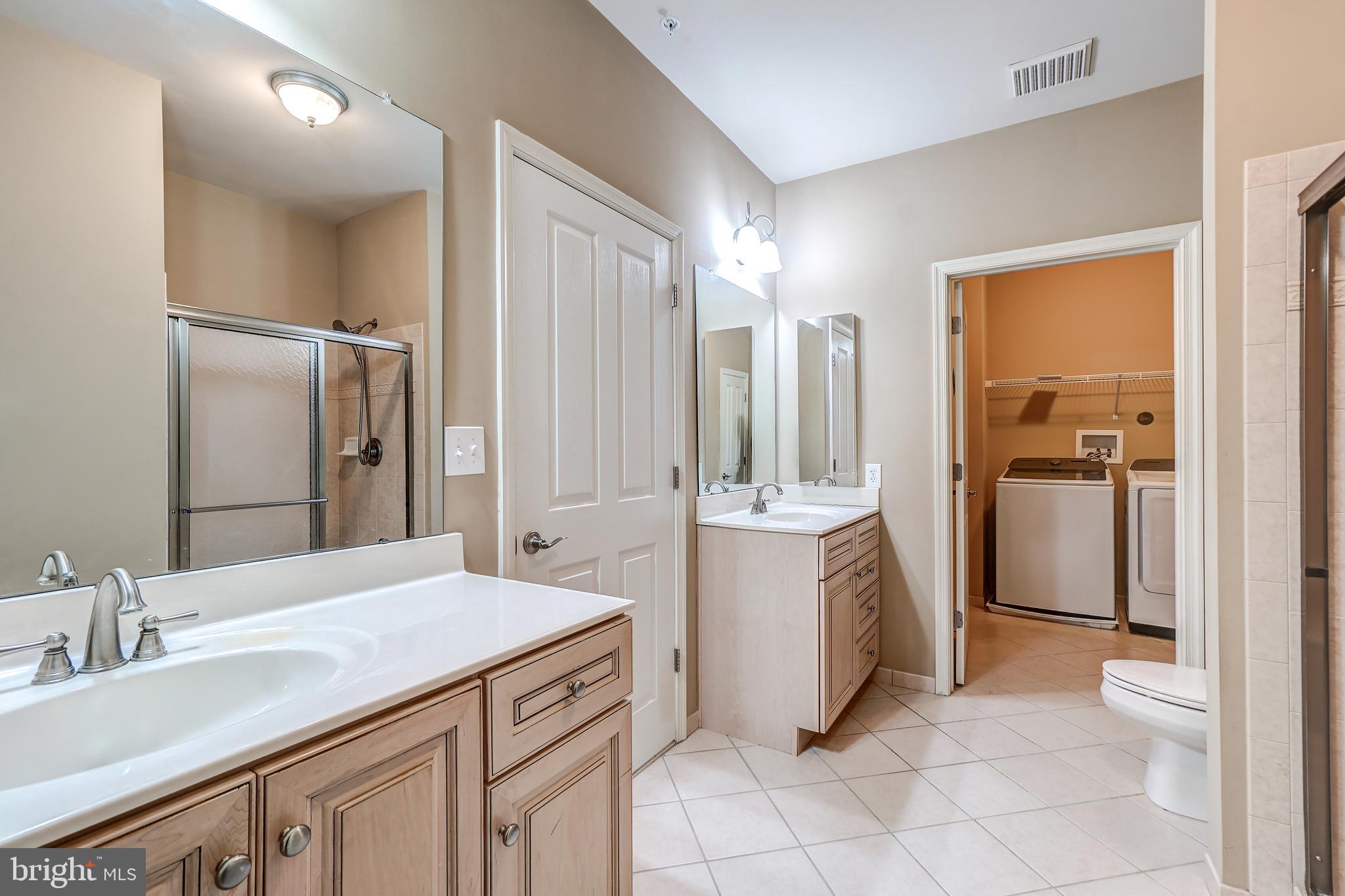 3030 Mill Island Parkway, Unit 109 Frederick, MD 21701 - Photo 15 of 20 a bathroom with a double vanity sink a mirror and a shower