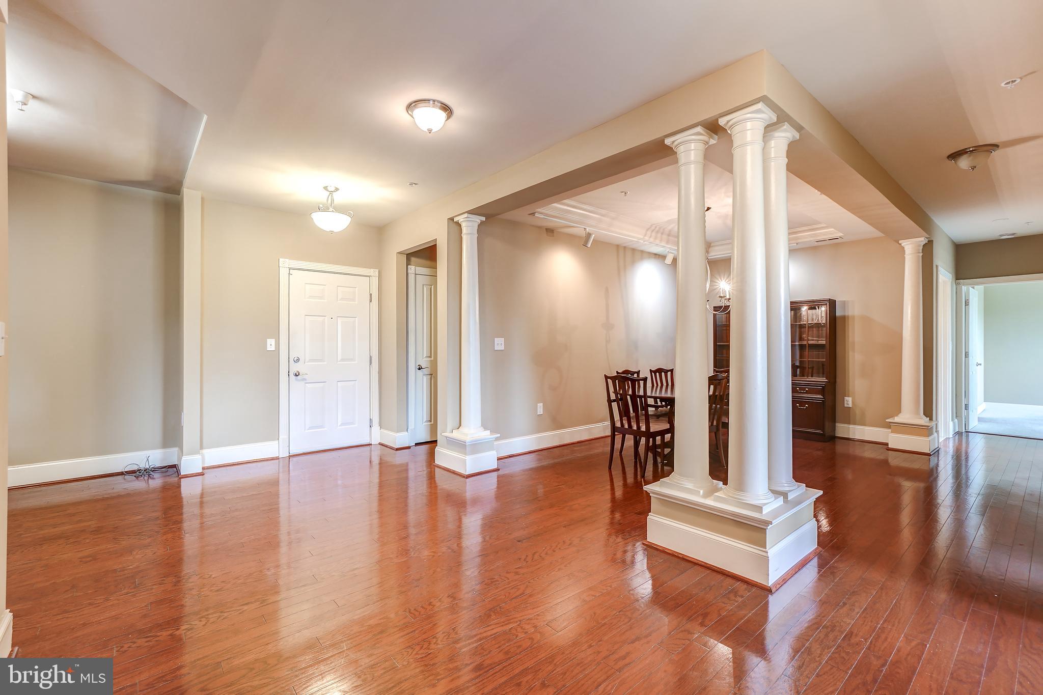 3030 Mill Island Parkway, Unit 109 Frederick, MD 21701 - Photo 10 of 20 a hallway with wooden floor and glass door