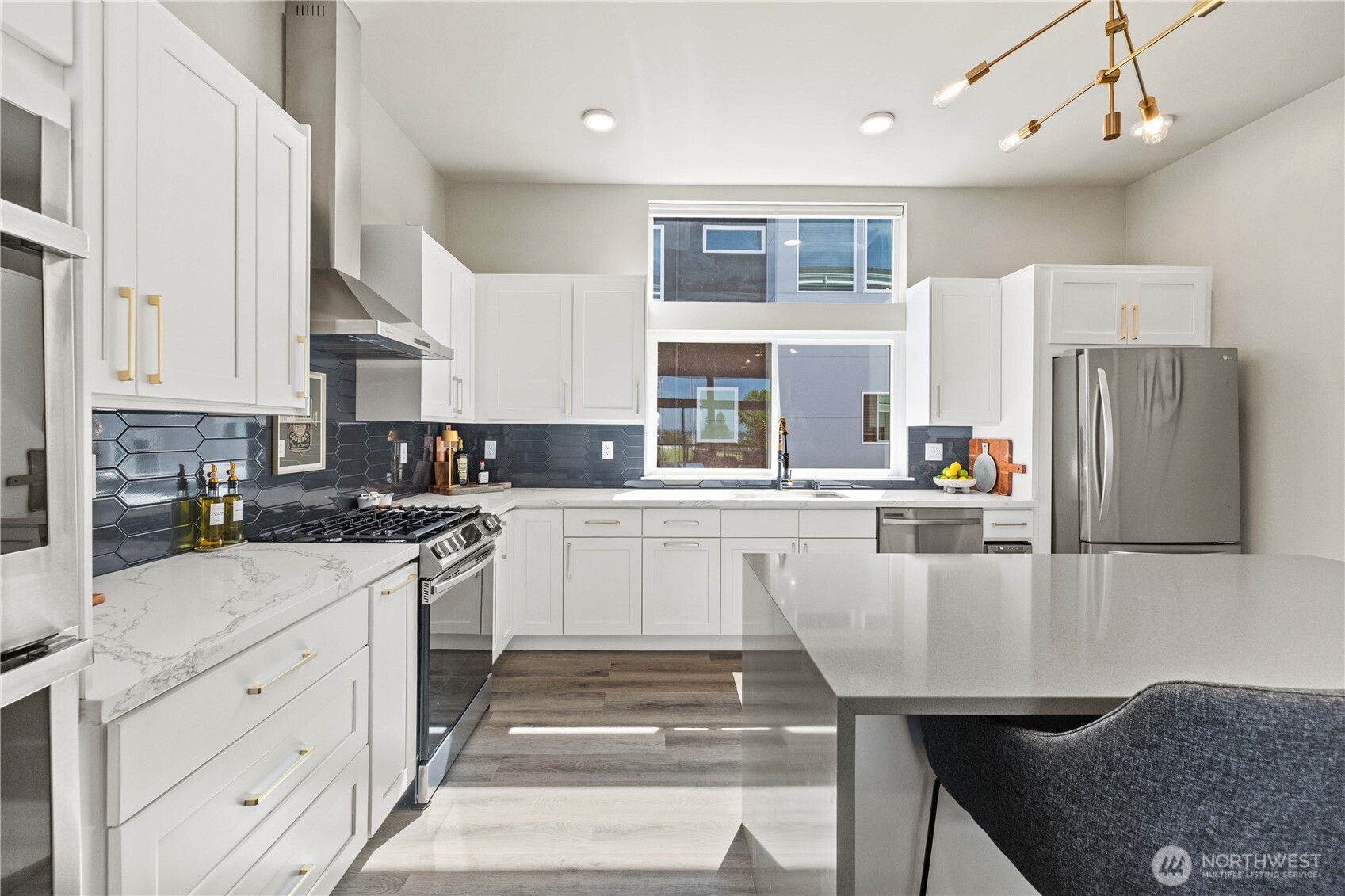 1208 Harrington Avenue Northeast Renton, WA 98056 - Photo 12 of 40 a kitchen with white cabinets and stainless steel appliances
