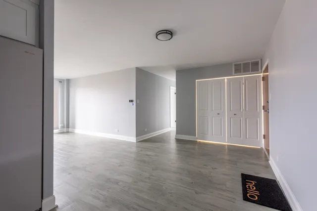 a view of an empty room with wooden floor